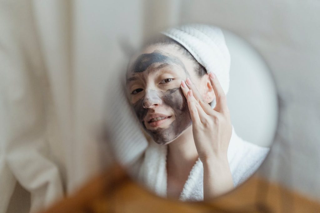 uvodni-fotka A woman enjoying a beauty routine with a face mask in an indoor setting.